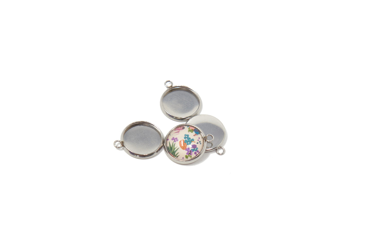 Front and back view of 12mm round stainless steel pendant settings on a light stone background, showing the bezel cup and smooth reverse side.
