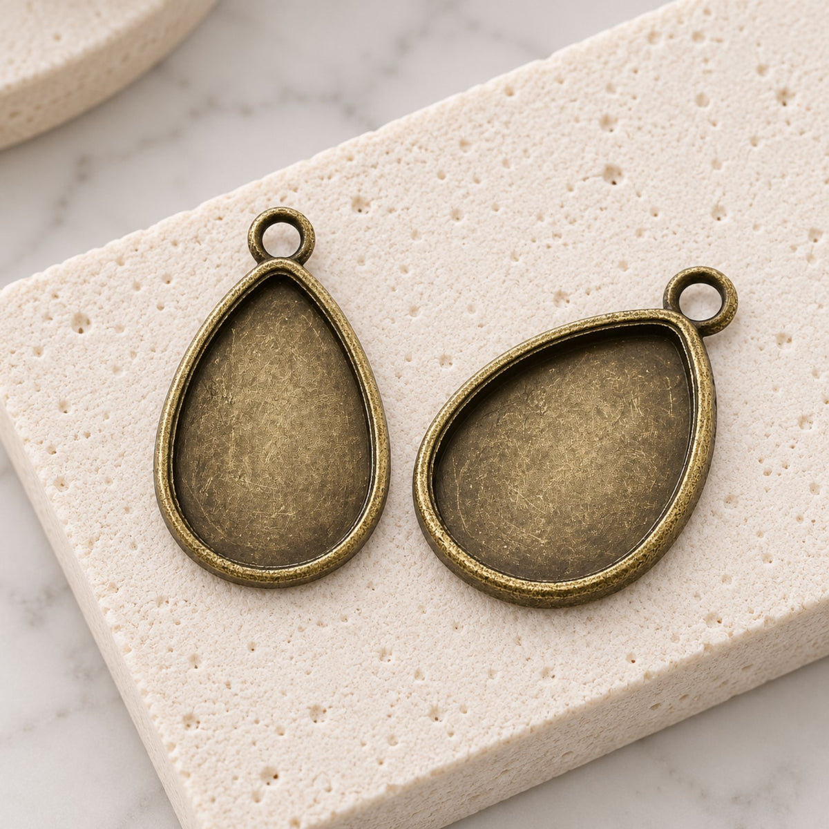 Close-up of vintage-style teardrop cabochon settings with an antique bronze finish.