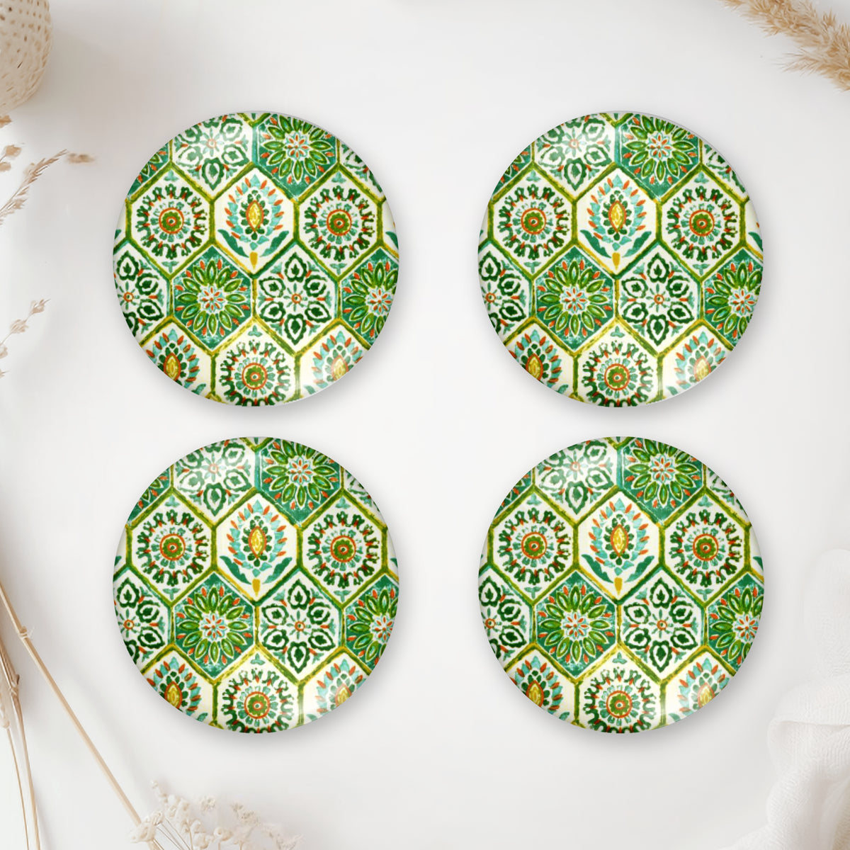 Four round glass domes with a green ornamental tile pattern for handmade jewelry making