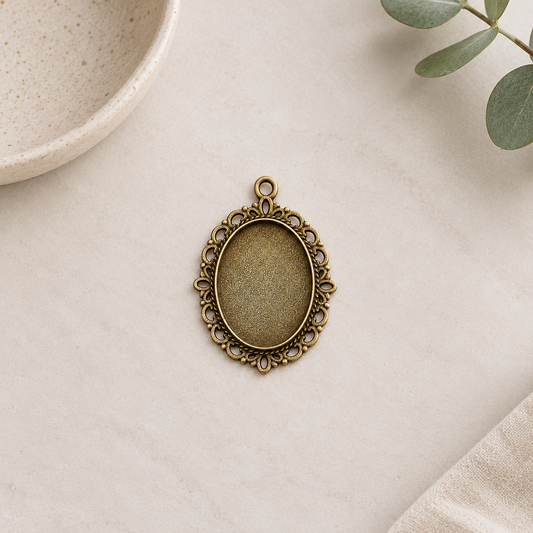 Front view of an antique bronze oval cabochon setting showing its decorative border and recessed 18x25mm tray.