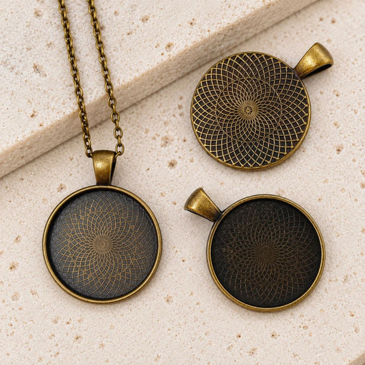 Close-up of vintage-style bronze pendant trays, one with a matching chain, ideal for handmade necklaces and cabochon jewelry projects.