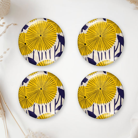 Round handmade glass cabochon with yellow floral pattern and dark blue details