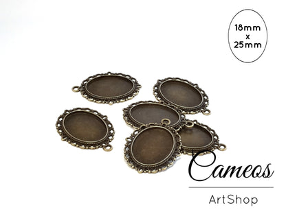 Antique bronze oval pendant bezel with a patterned base and decorative metal frame on a white background.