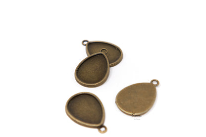 Antique bronze teardrop pendant blanks showing the recessed trays for 18x25mm cabochons.
